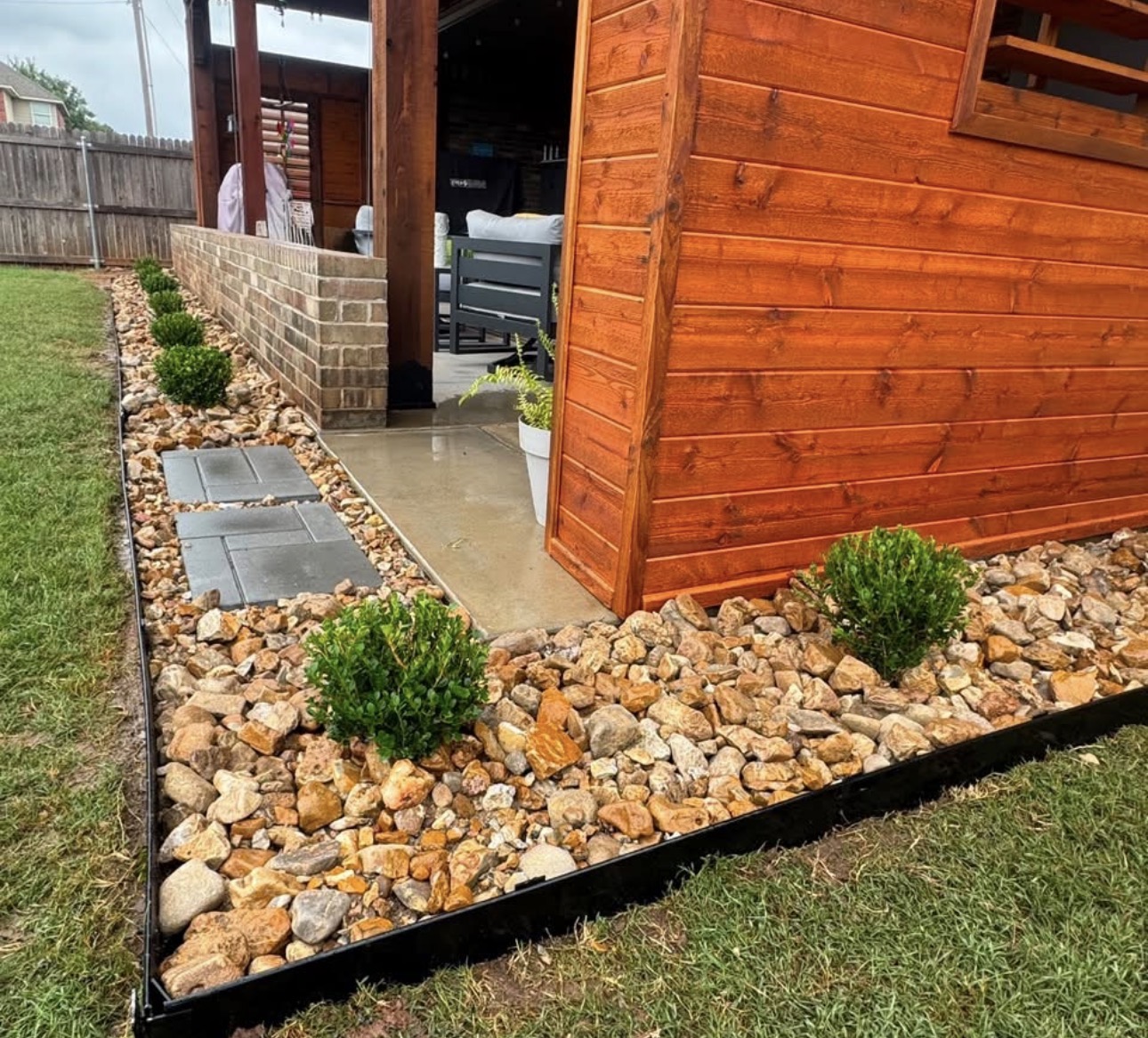 River rock bed with steel edging, pavers and trimmed boxwoods